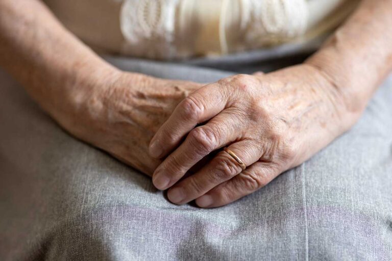 Older adult and family member tour a bright assisted living apartment with a caregiver.